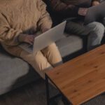 Laptop - Man and Woman Sitting on Gray Couch