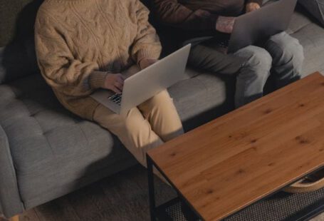 Laptop - Man and Woman Sitting on Gray Couch